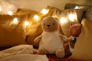 Warm and inviting bedroom scene with plush toys, pillows, and string lights creating a comforting ambiance.