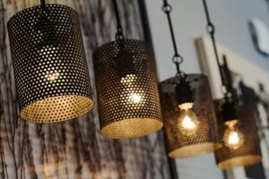 A row of modern perforated light fixtures hanging indoors, creating a cozy ambiance.