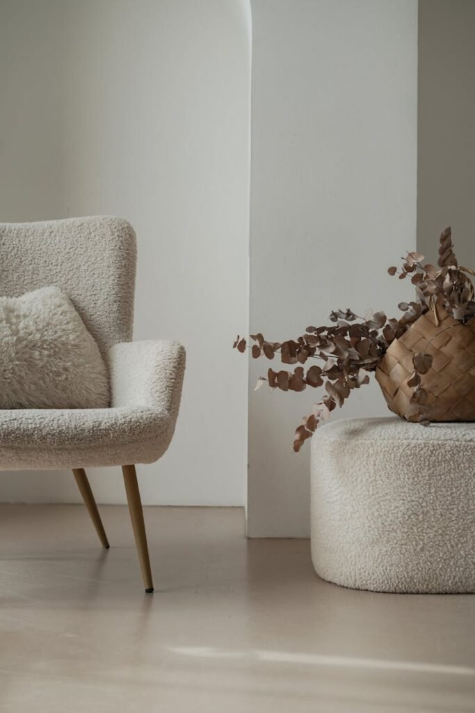 Serene minimalist living room featuring a soft fabric armchair and rustic decor elements.