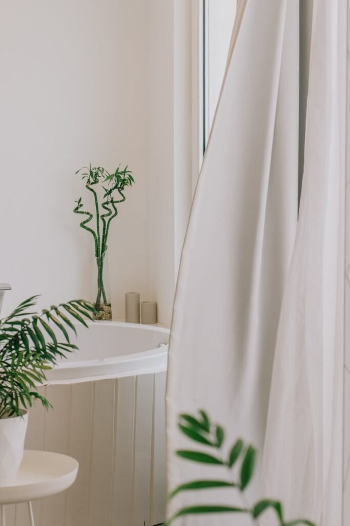 Modern bathroom featuring bamboo plants and white decor for a serene aesthetic.