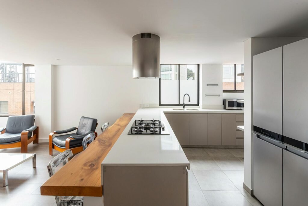 Bright and airy open-plan kitchen with armchairs showing a contemporary design.