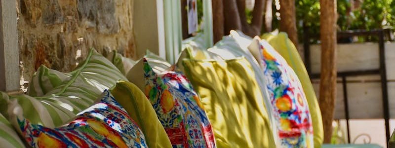 Vibrant outdoor cafe seating with colorful patterned cushions in a sunny setting.