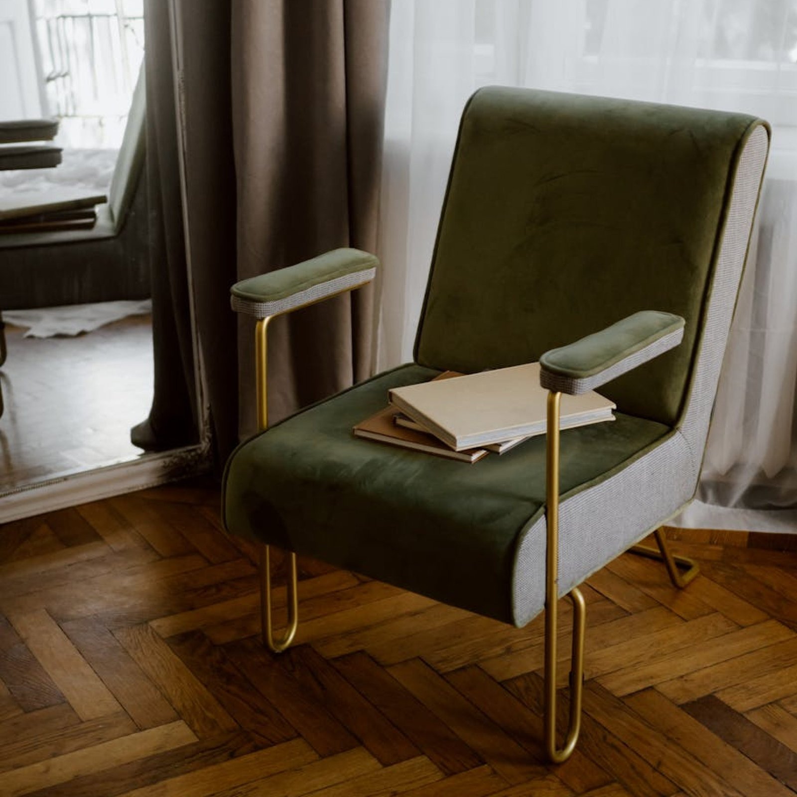 Photo by Polina ⠀ Stylish green armchair with gold legs in a contemporary apartment interior.