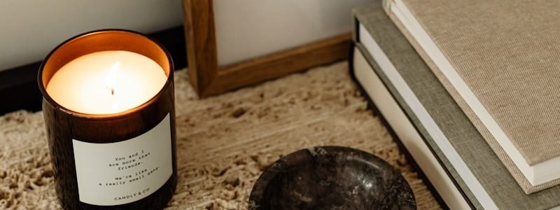 Lit candle and small dish on textured surface